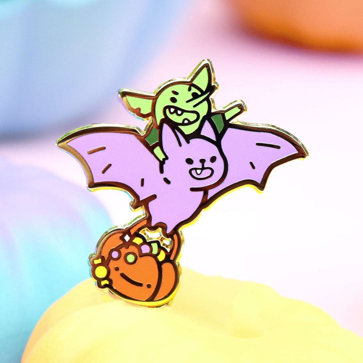 A mischievous goblin riding on the back of a flying bat. It looks like he is laughing as he points the bat in the direction he wants to go. The bat is smiling and carrying a big stolen halloween trick or treat bucket spilling candy
